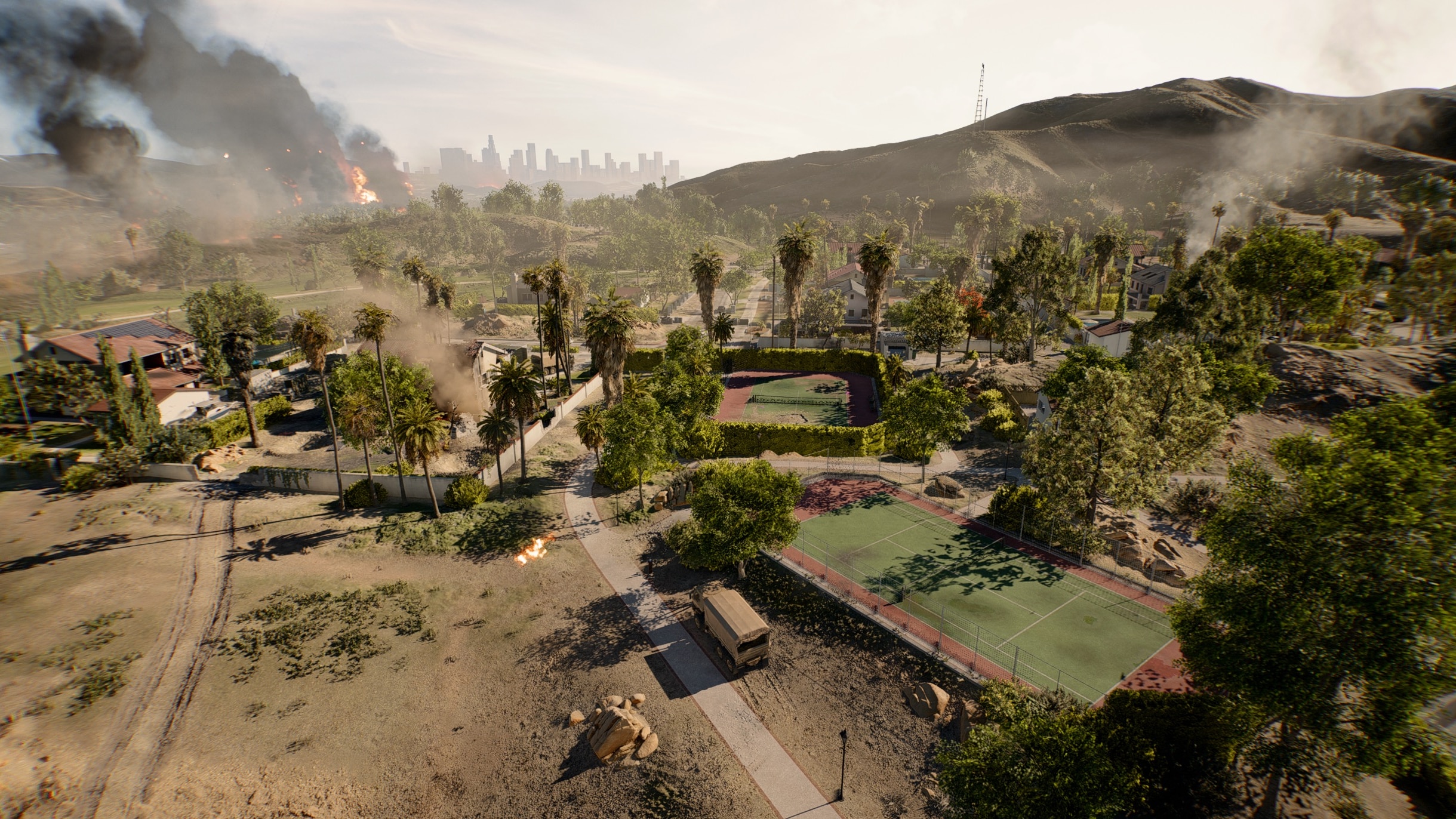 A suburban neighborhood with houses, trees, and tennis courts is disrupted by smoke and fire. A city skyline is visible in the distance.
